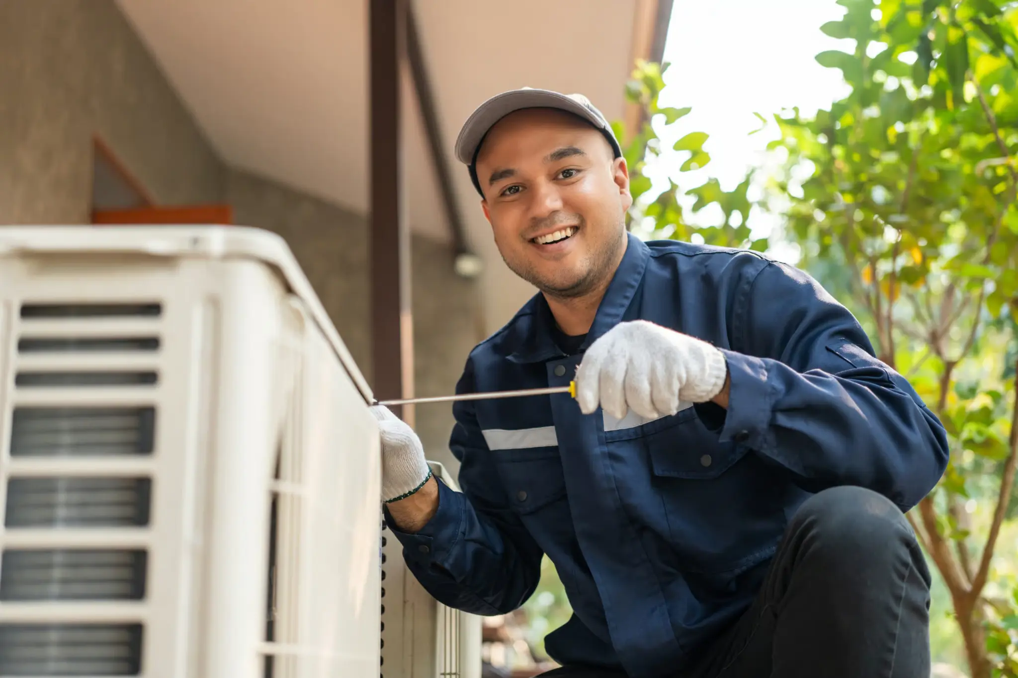 Technician inspecting a residential outdoor air conditioning unit